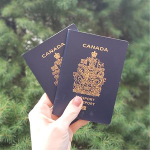 Immigrant résident au Québec tenant dans la main son passeport canadien après avoir obtenu sa citoyenneté canadienne